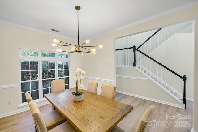 dining space with stairway, visible vents, light wood-style floors, and ornamental molding