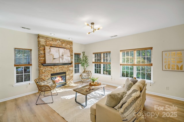 living area featuring a fireplace, visible vents, and wood finished floors