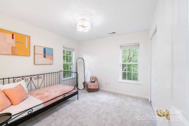 carpeted bedroom featuring a closet, visible vents, and baseboards