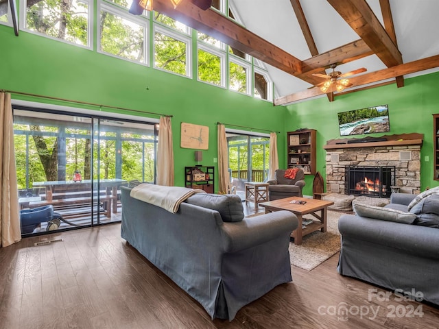 living room featuring high vaulted ceiling, beam ceiling, dark hardwood / wood-style flooring, and a stone fireplace