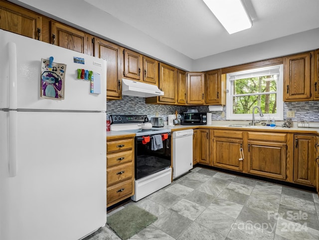 kitchen featuring decorative backsplash, sink, and white appliances