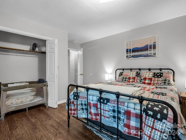 bedroom featuring a textured ceiling, a closet, and dark hardwood / wood-style floors