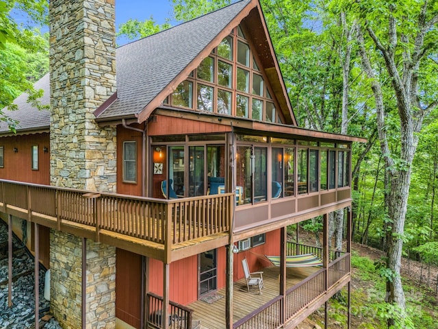 rear view of property featuring a deck and a sunroom