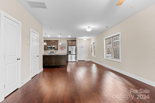 unfurnished living room with dark wood-type flooring and ceiling fan