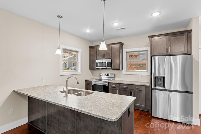 kitchen featuring kitchen peninsula, dark hardwood / wood-style flooring, stainless steel appliances, sink, and decorative light fixtures