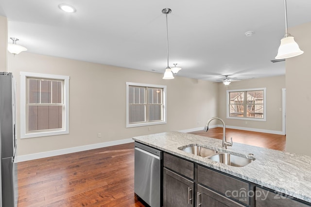 kitchen featuring appliances with stainless steel finishes, sink, dark wood-type flooring, dark brown cabinetry, and decorative light fixtures