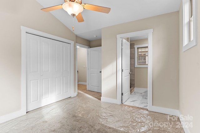 unfurnished bedroom featuring lofted ceiling, a closet, and ceiling fan