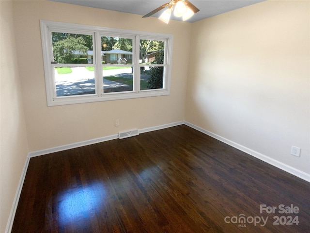 unfurnished room featuring ceiling fan, dark hardwood / wood-style floors, and a wealth of natural light