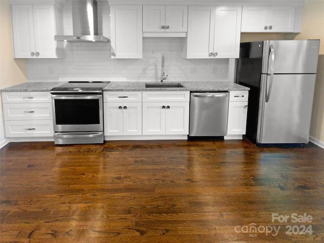 kitchen with sink, wall chimney range hood, stainless steel appliances, and white cabinetry