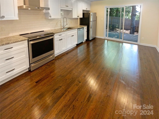 kitchen with white cabinets, appliances with stainless steel finishes, sink, and wall chimney exhaust hood