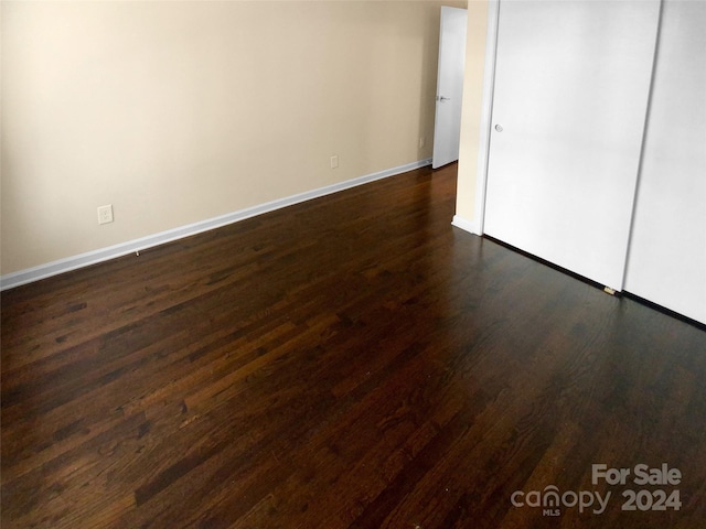 unfurnished bedroom with dark hardwood / wood-style flooring