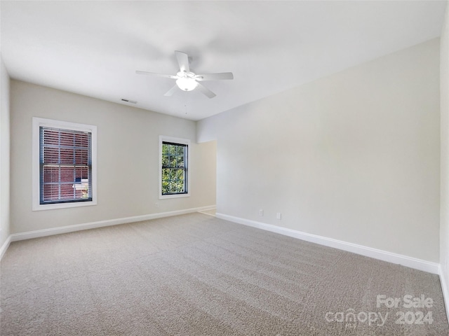 carpeted spare room featuring ceiling fan