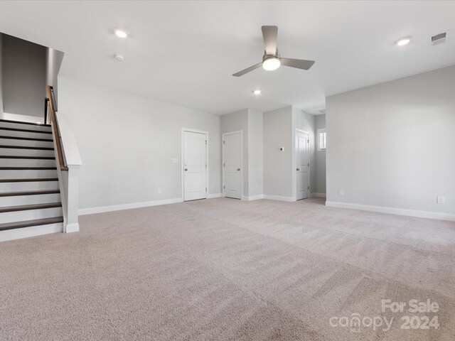 unfurnished living room featuring ceiling fan and light colored carpet