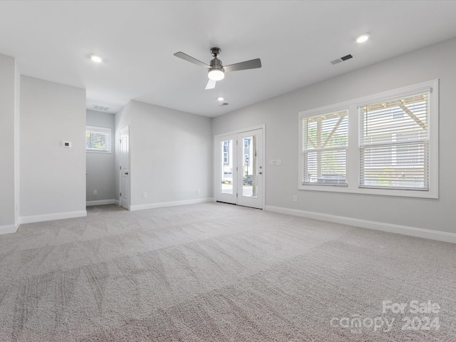 carpeted spare room with ceiling fan and a wealth of natural light