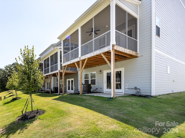 rear view of house with a lawn, ceiling fan, a patio area, and a sunroom