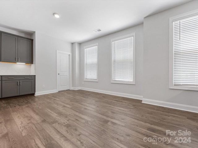 unfurnished living room featuring a wealth of natural light and hardwood / wood-style flooring