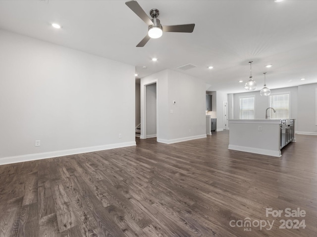 unfurnished living room with ceiling fan, dark hardwood / wood-style flooring, and sink