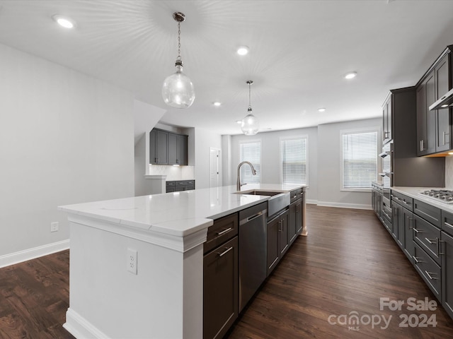 kitchen featuring dark hardwood / wood-style flooring, sink, an island with sink, and stainless steel appliances