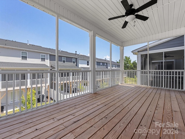 wooden terrace with a sunroom and ceiling fan