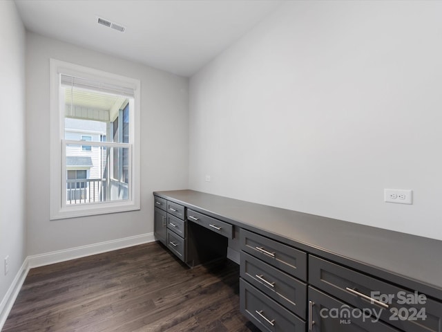 office space featuring built in desk and dark wood-type flooring