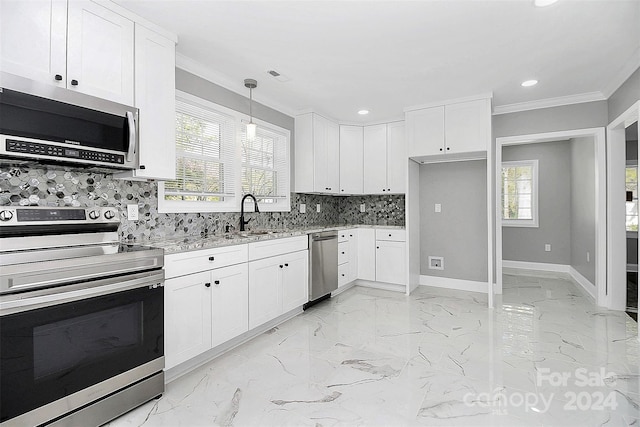 kitchen featuring stainless steel appliances, white cabinetry, hanging light fixtures, and sink