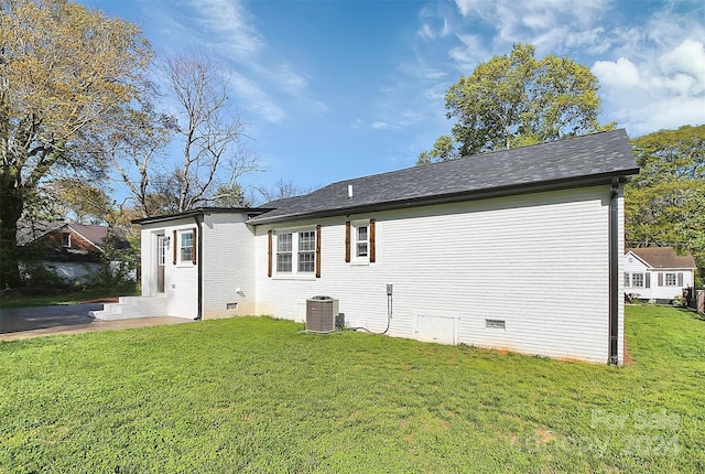 back of property featuring a yard and central AC