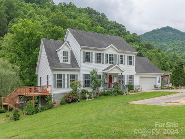 view of front of house with a garage, a front lawn, and a mountain view