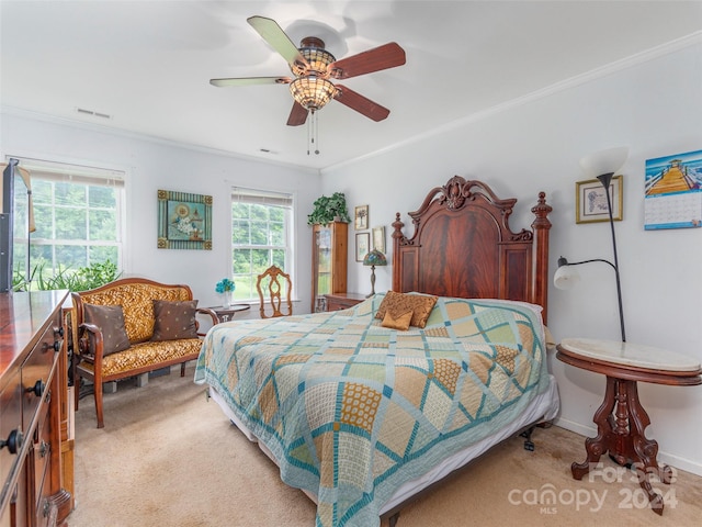 carpeted bedroom featuring ceiling fan and crown molding