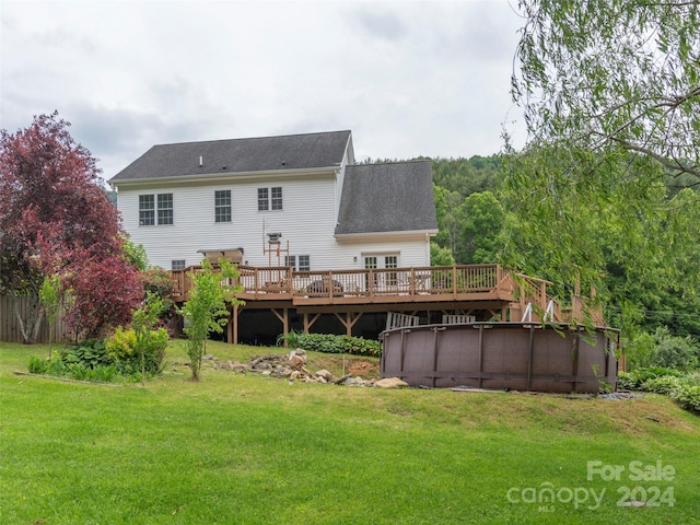 back of property featuring a lawn and a swimming pool side deck