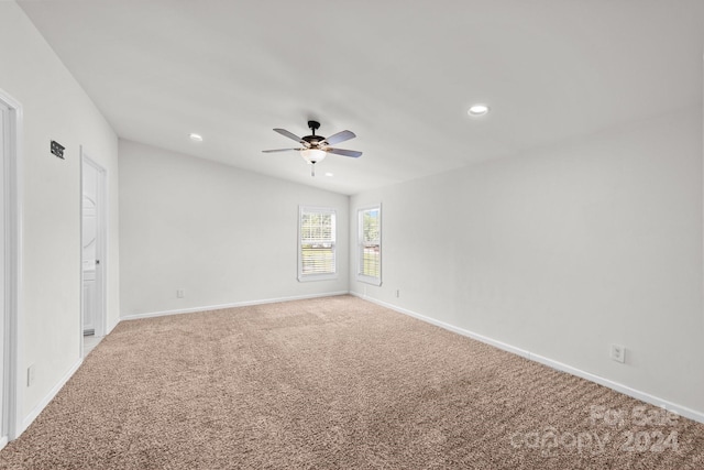 carpeted spare room with ceiling fan and vaulted ceiling