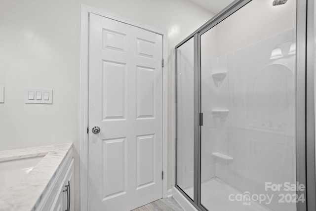 bathroom featuring vanity and a shower with door