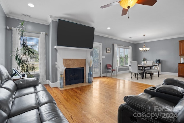 living room with light wood-type flooring, plenty of natural light, and crown molding