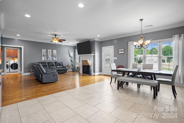 dining area with ceiling fan with notable chandelier, independent washer and dryer, ornamental molding, and light tile patterned floors