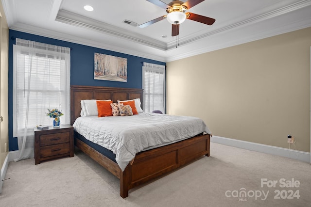 bedroom with light colored carpet, ceiling fan, a raised ceiling, and ornamental molding