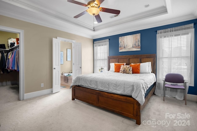 carpeted bedroom featuring a spacious closet, ceiling fan, a raised ceiling, a closet, and ornamental molding