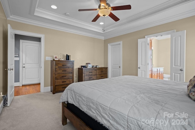 carpeted bedroom with a raised ceiling, connected bathroom, ceiling fan, and crown molding