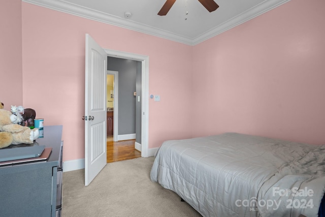 carpeted bedroom with ceiling fan and ornamental molding