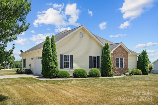 view of side of home with a lawn and a garage