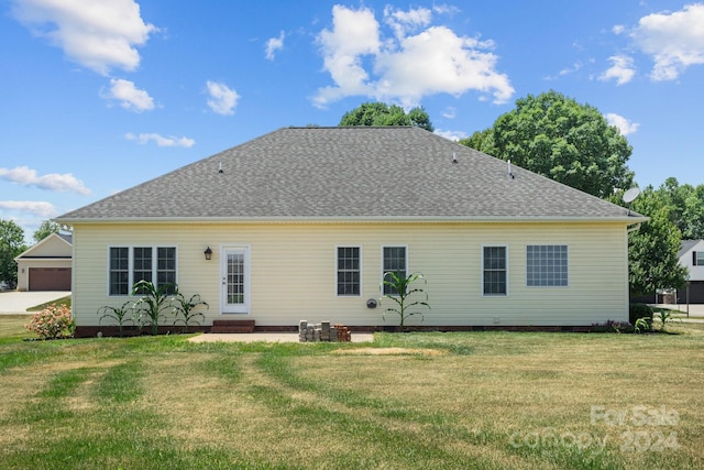 rear view of property featuring a lawn and a patio