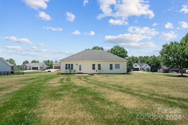 rear view of property featuring a lawn