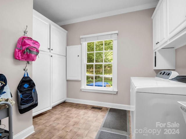 clothes washing area featuring cabinets, separate washer and dryer, and crown molding