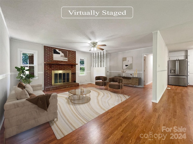 living room with hardwood / wood-style floors, a healthy amount of sunlight, and a textured ceiling