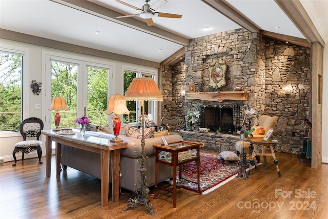 living room with ceiling fan, a fireplace, lofted ceiling with beams, and wood-type flooring