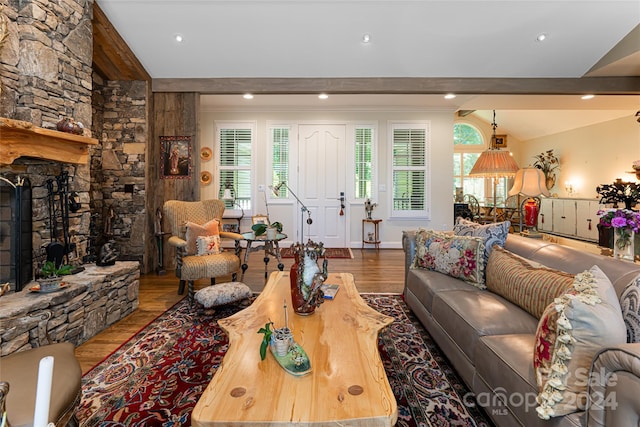 living room with a fireplace, wood-type flooring, and lofted ceiling with beams