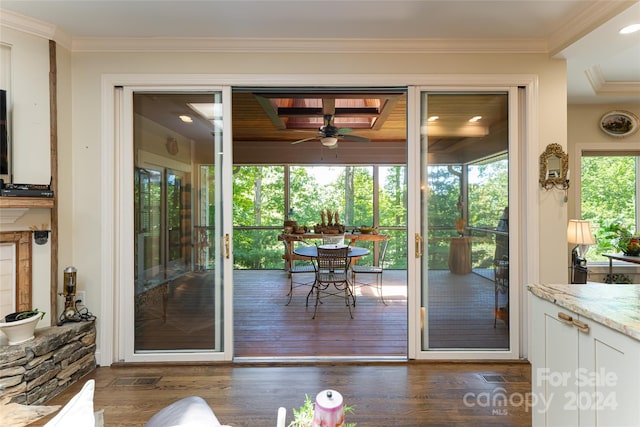 doorway to outside featuring ceiling fan, crown molding, and dark wood-type flooring