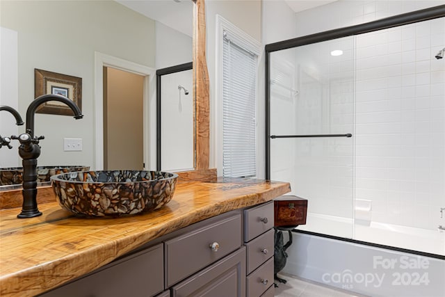 bathroom featuring shower / bath combination with glass door and vanity