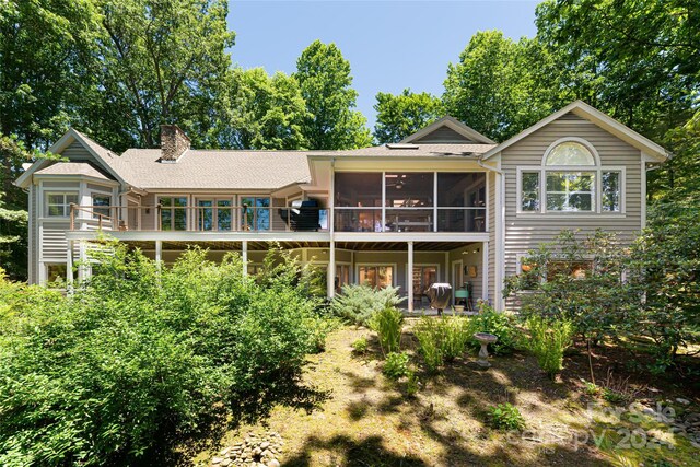 rear view of property featuring a sunroom