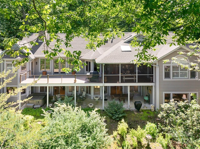 rear view of house featuring a patio area and a hot tub