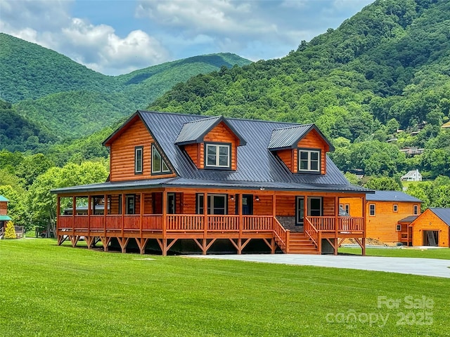back of property featuring a yard, a porch, metal roof, log veneer siding, and a mountain view