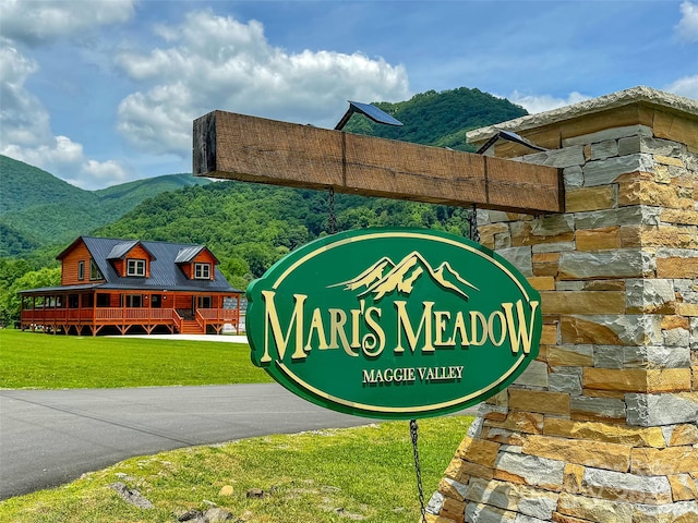community sign featuring a yard and a mountain view